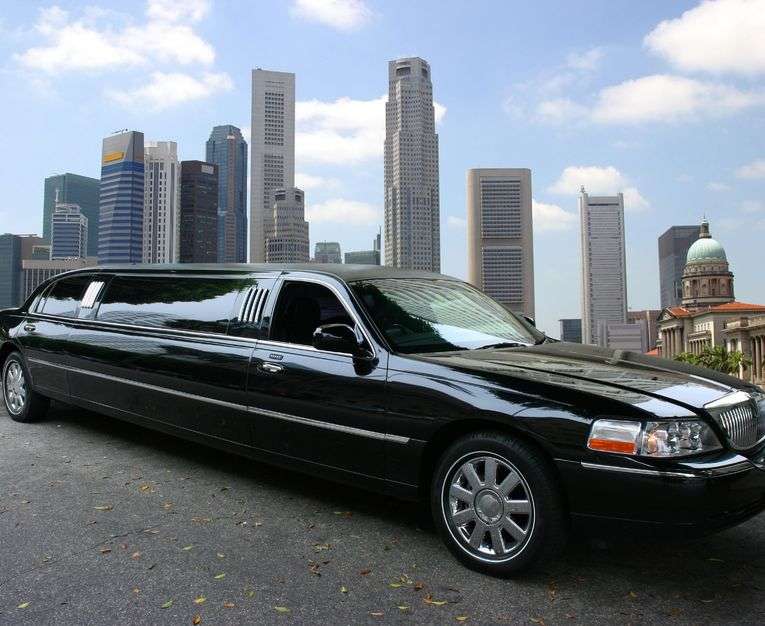 Stretch limo with a city skyline in the background.